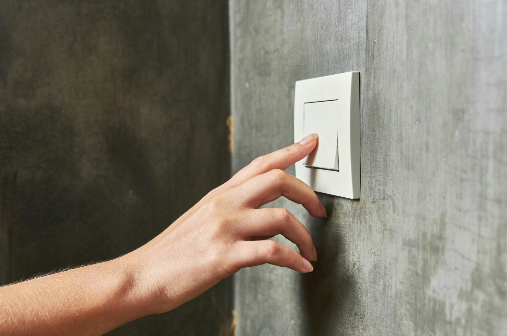 Person using light switch.
