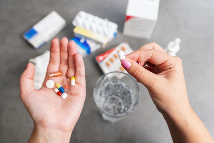 Image of a woman holding different medications