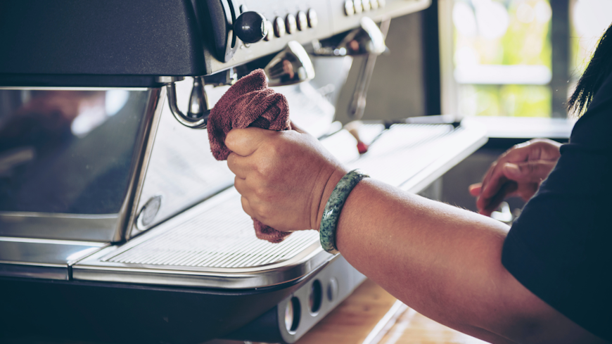 Image of woman cleaning a coffee machine