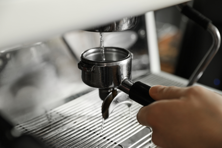 Image of woman cleaning portafilter on her coffee machine