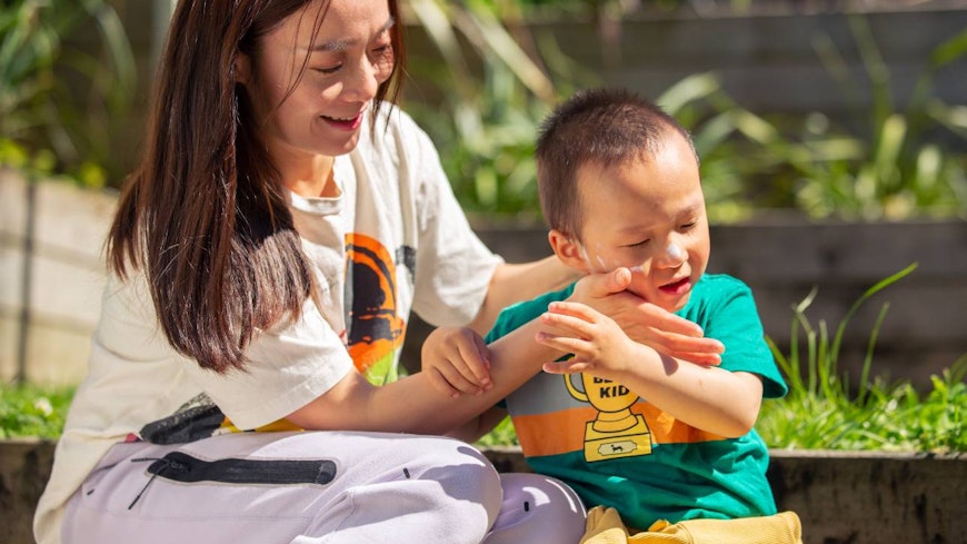 Image of a mother applying sunscreen to her child