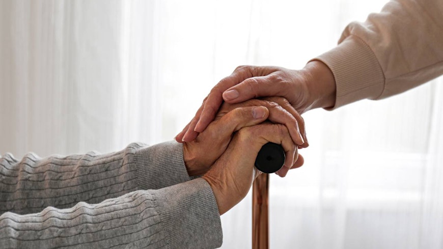 Image of an elderly holding a walking stick