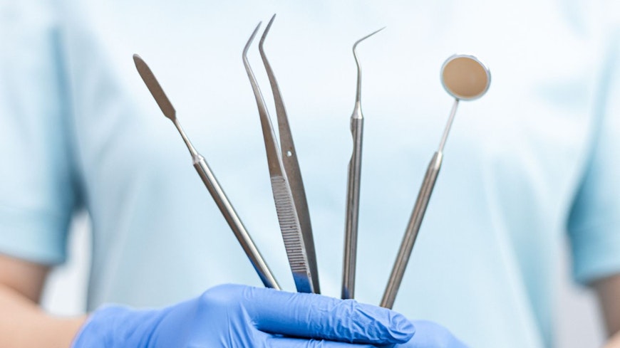 Image of a dentist holding tools