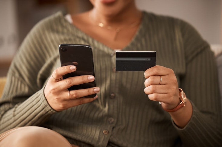 Image of a woman holding a phone and credit card