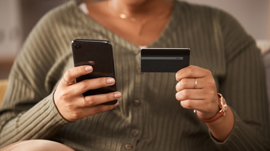 Image of a woman holding a phone and credit card