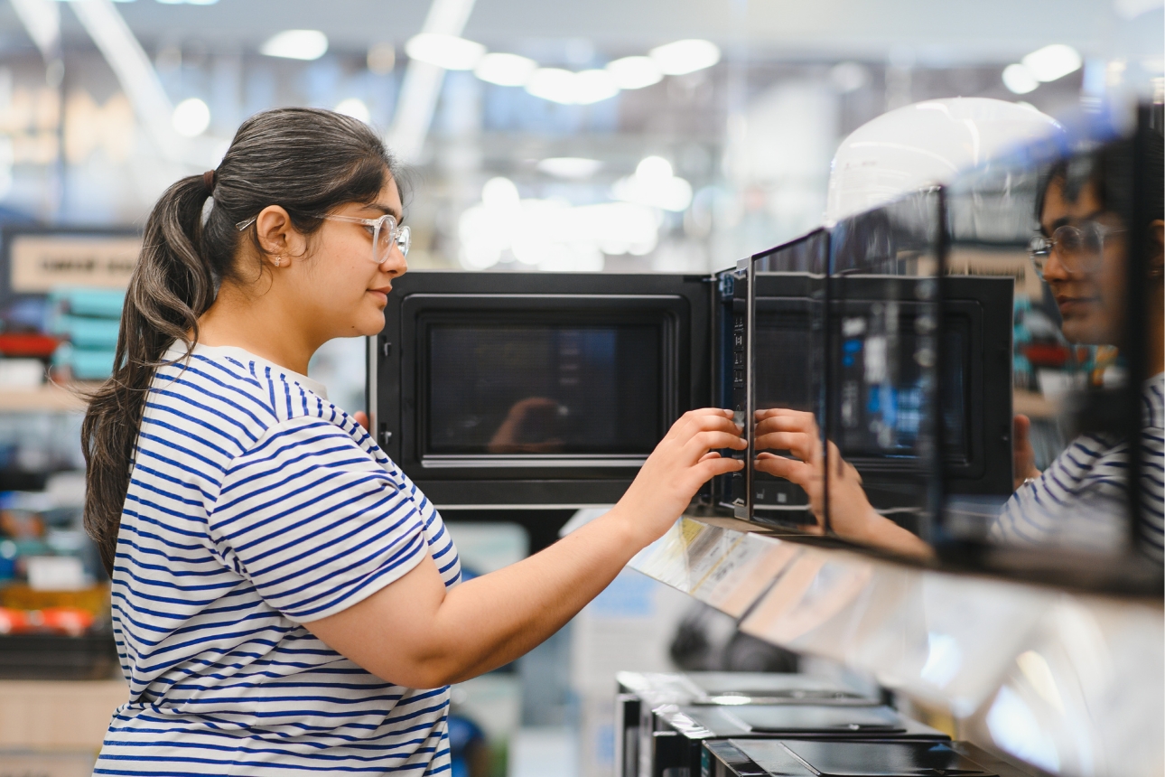 Woman shopping for a microwave.