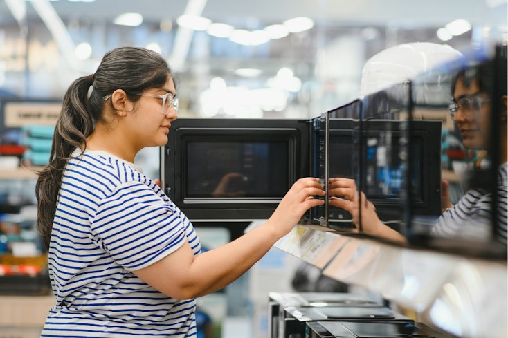 Woman shopping for a microwave.