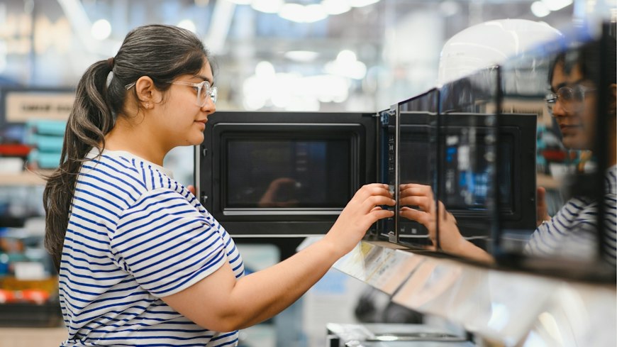 Woman shopping for a microwave.