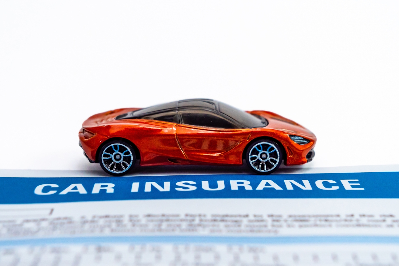 Toy car on paper that says 'car insurance'.