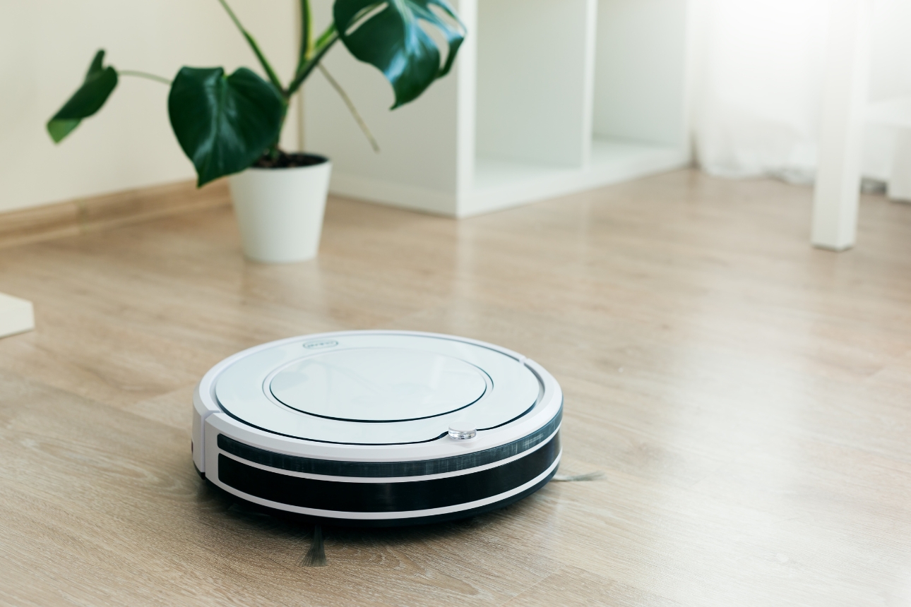 Robot vacuum on wooden floor.