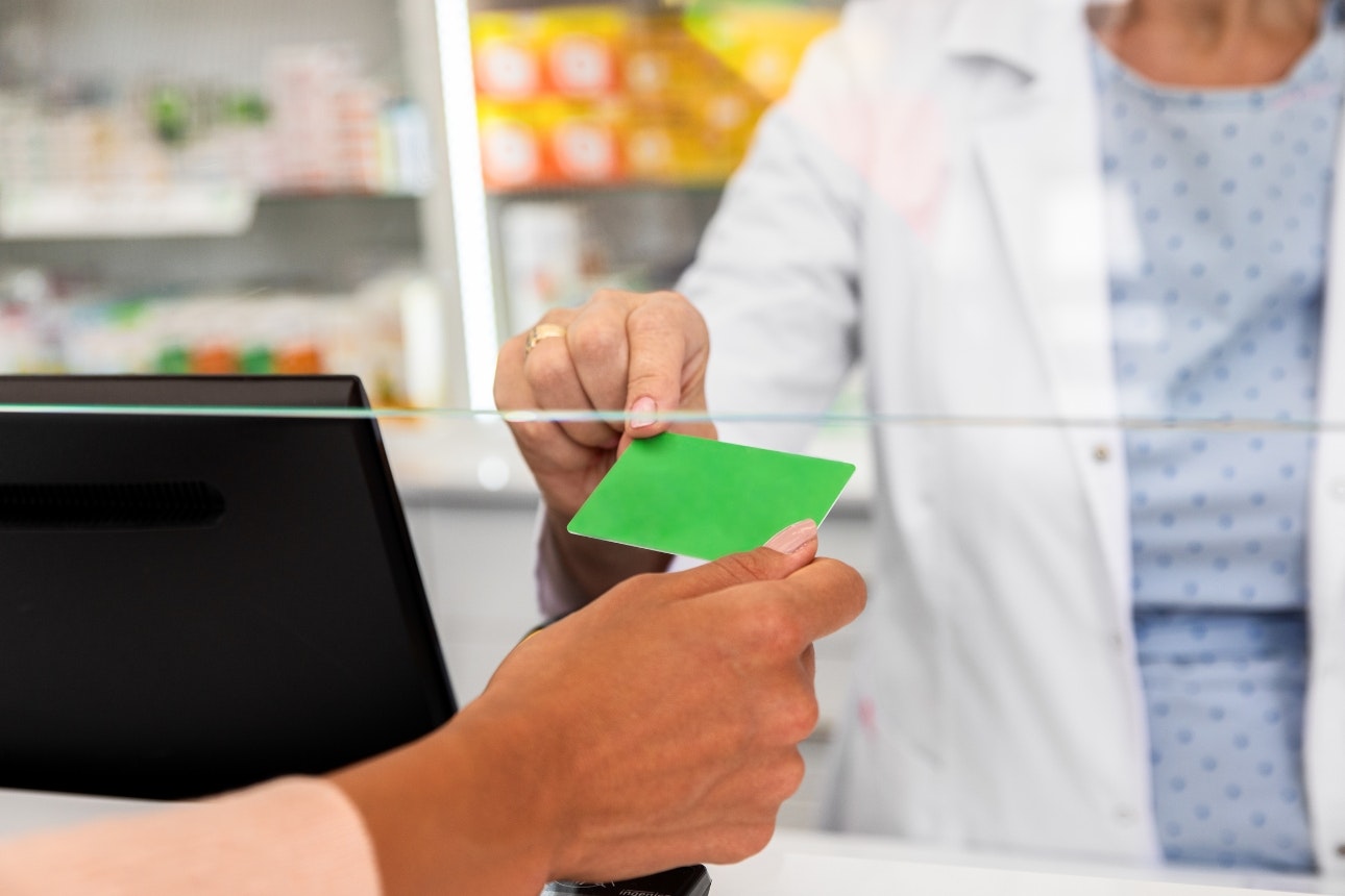 Lady giving cashier a loyalty card to scan.