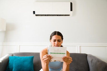 Woman looking distressed at power bill.