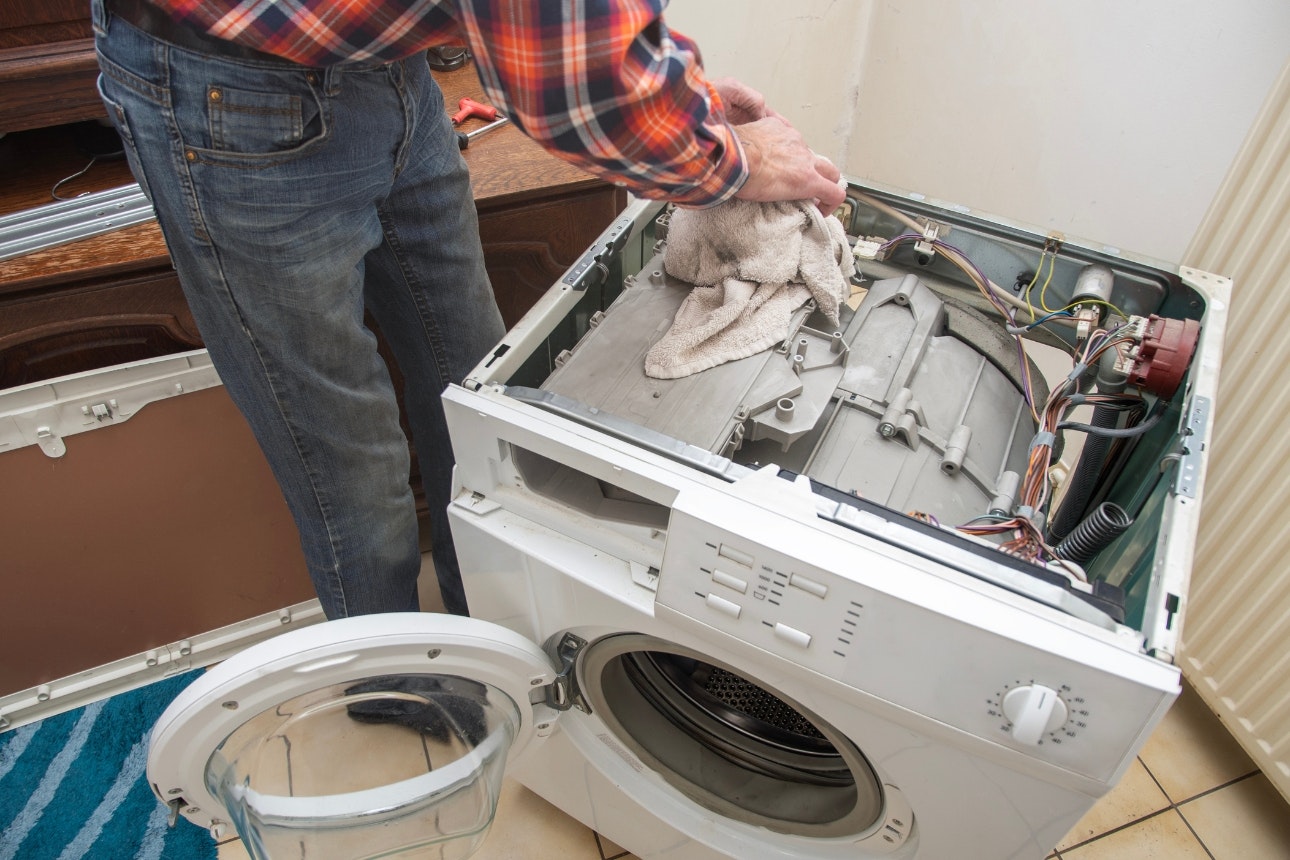 Man repairing washing machine.