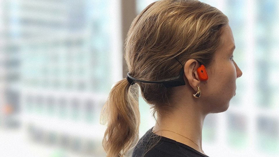 Woman wearing Suunto Wing 2 headphones.