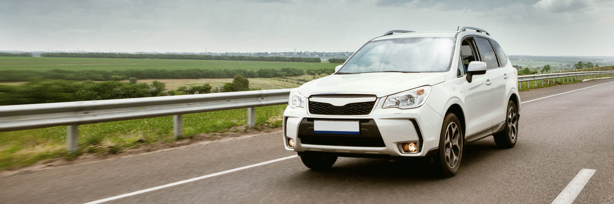 Blue SUV on road near mountain in New Zealand.
