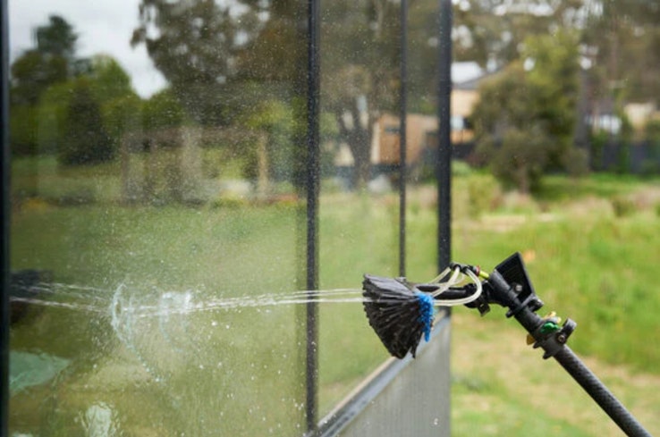Water fed brush cleaning window.