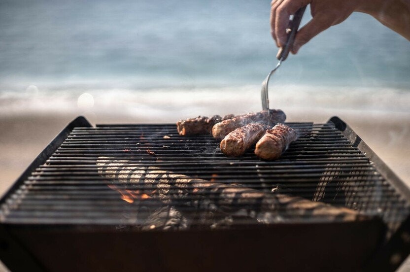 Cooking sausages on a BBQ.
